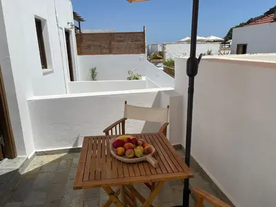 a bowl of fruit sitting on a table on a balcony at Teresa's Home in Líndos