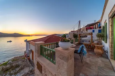 a balcony with a view of the water and buildings at Muse Clio in Halki