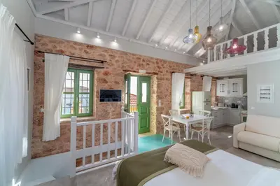 a bedroom with a bed and a kitchen with a table at Muse Clio in Halki