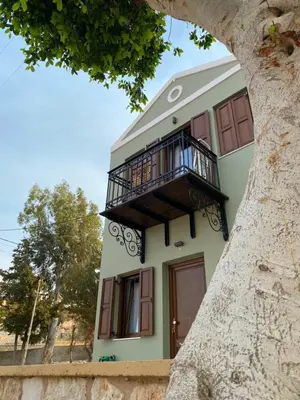 a house with a balcony on top of it at Celestia Apartments in Halki