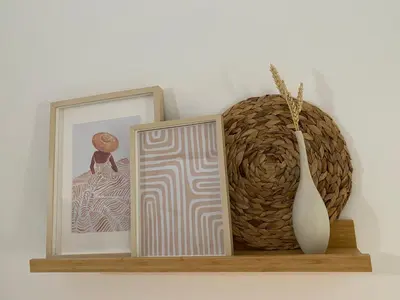 a shelf with two pictures and a vase on it at Celestia Apartments in Halki