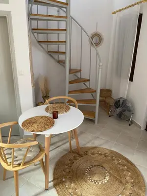 a table and chairs in a room with a staircase at Celestia Apartments in Halki