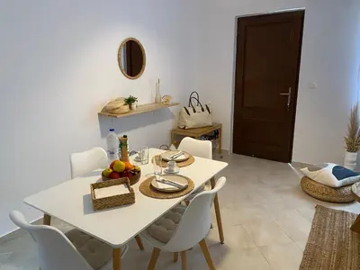 a dining room with a white table and chairs at Celestia Apartments in Halki