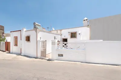 a white house with a gate on a street at Traditional House Leventis in Archangelos