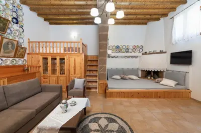 a living room with a couch and a bed at Traditional House Leventis in Archangelos