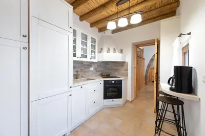 a kitchen with white cabinets and a stove at Traditional House Leventis in Archangelos