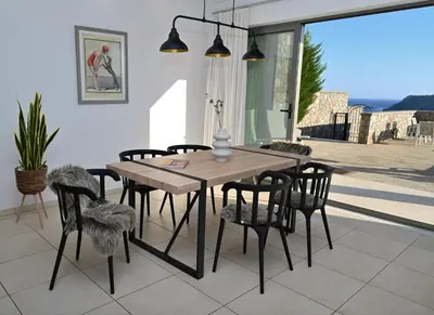 a dining room with a wooden table and chairs at Villa Vitabel sea view in Lindos in Líndos