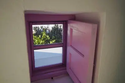 a pink window in a room with a view at The Summer Pink House in Lachania