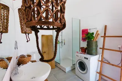 a bathroom with a sink and a washing machine at The Summer Pink House in Lachania