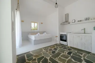 a white living room with a couch and a kitchen at Elia Suites in Triánta