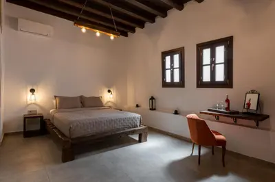 a bedroom with a bed and a chair in it at Ancient Knights Luxury Suites in Rhodes Town