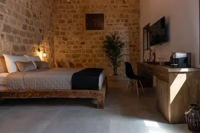 a bedroom with a bed and a desk and a television at Ancient Knights Luxury Suites in Rhodes Town