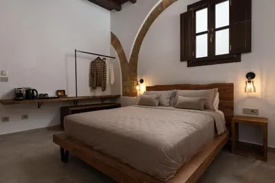 a bedroom with a large bed with a wooden frame at Ancient Knights Luxury Suites in Rhodes Town