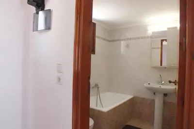 a bathroom with a sink and a tub and a toilet at Anastasia Apartments (Chorio) in Symi