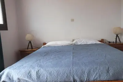 a bedroom with a bed with a blue comforter and two lamps at Anastasia Apartments (Chorio) in Symi