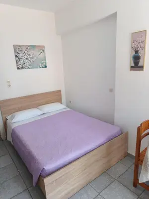 a bedroom with a bed with a purple blanket at Anastasia Apartments (Chorio) in Symi