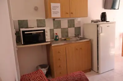 a small kitchen with a microwave and a refrigerator at Anastasia Apartments (Chorio) in Symi