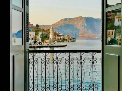 a view of the water from a balcony at 1900 Hotel in Symi