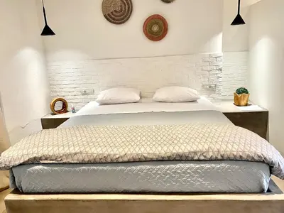a bedroom with a bed with a white brick wall at Rhodes Old Town Harmony Suite in Rhodes Town