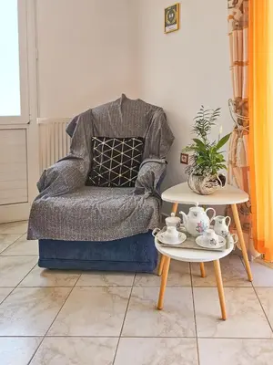 a living room with a chair and a table at Rodini Sun Apartment in Rhodes Town