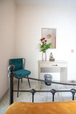 a glass table and a green chair in a room at Rodini Sun Apartment in Rhodes Town