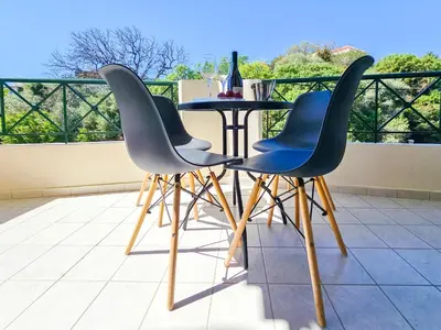 a table and four chairs on a balcony at Rodini Sun Apartment in Rhodes Town