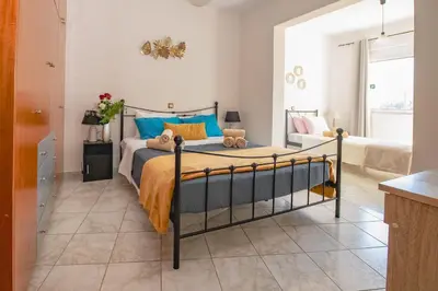 a bedroom with a bed with blue and yellow pillows at Rodini Sun Apartment in Rhodes Town