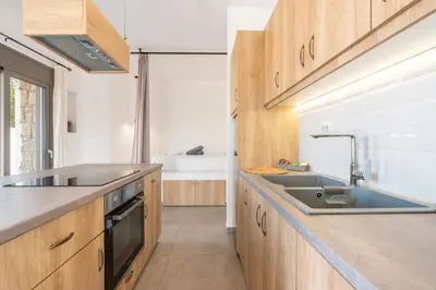 a kitchen with wooden cabinets and a sink at Kiotari Fresh in Kiotari