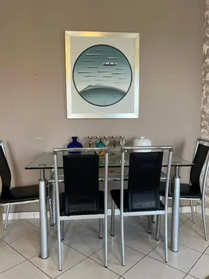 a dining room table with chairs and a picture on the wall at Appartment by the beach in Rhodes Town