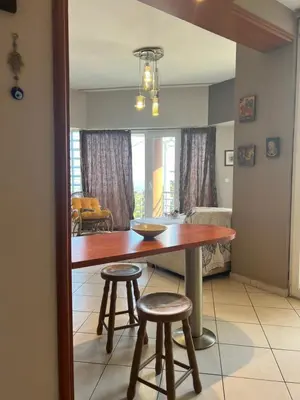 a dining room with a table and two stools at Appartment by the beach in Rhodes Town