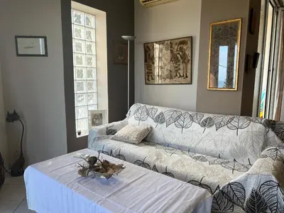 a living room with a white couch and a table at Appartment by the beach in Rhodes Town