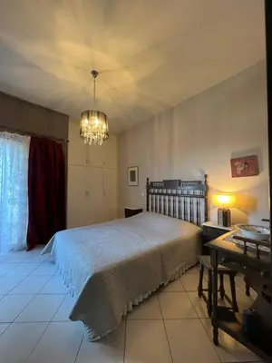 a bedroom with a large bed and a chandelier at Appartment by the beach in Rhodes Town
