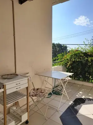 a table and a chair in a room with a window at Appartment by the beach in Rhodes Town