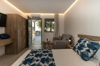 a bedroom with a bed and a living room at POUNEDES LUXURY SUITES in Pefki Rhodes