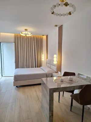 a hotel room with a bed and a table at POUNEDES LUXURY SUITES in Pefki Rhodes