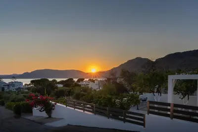 a sunset from a house with a view of the ocean at POUNEDES LUXURY SUITES in Pefki Rhodes