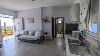 a kitchen and living room with a couch and a sink at KIRA'S RESIDENCE PANORAMIC VIEW in Archangelos