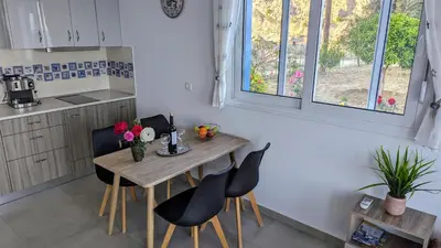a kitchen with a wooden table with chairs and flowers on it at KIRA'S RESIDENCE PANORAMIC VIEW in Archangelos