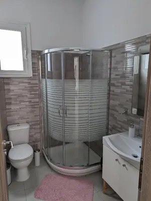 a bathroom with a shower and a toilet and a sink at KIRA'S RESIDENCE PANORAMIC VIEW in Archangelos