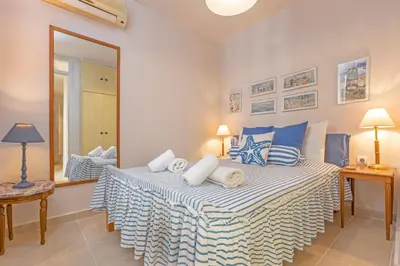 a bedroom with a large bed with blue and white sheets at Hidden Gem of Afandou , Traditional House & Patio in Afantou