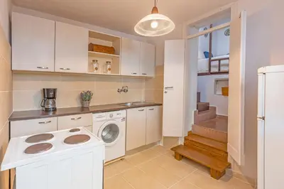 a kitchen with a washing machine and a staircase at Hidden Gem of Afandou , Traditional House & Patio in Afantou