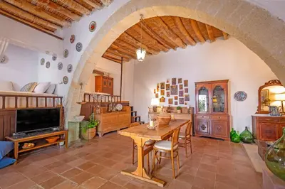 a living room with a wooden table and an archway at Hidden Gem of Afandou , Traditional House & Patio in Afantou