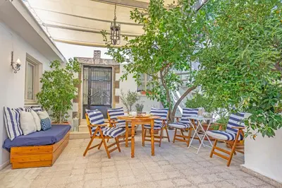 a patio with a table and chairs and a couch at Hidden Gem of Afandou , Traditional House & Patio in Afantou