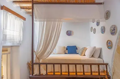 a bed in a room with a curtain at Hidden Gem of Afandou , Traditional House & Patio in Afantou