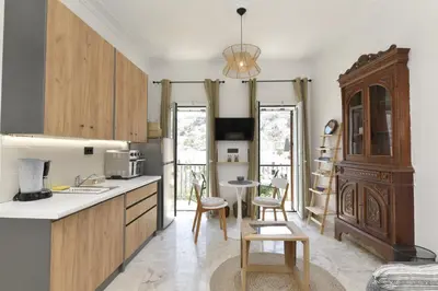 a kitchen with wooden cabinets and a table and chairs at Centrale Apartment Symi in Symi