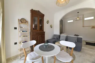 a living room with a table and chairs and a couch at Centrale Apartment Symi in Symi