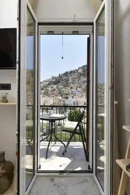 a room with sliding glass doors leading to a balcony at Centrale Apartment Symi in Symi