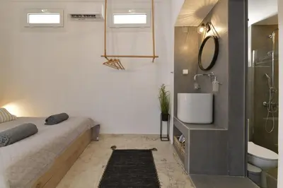a bedroom with a bed and a shower and a sink at Centrale Apartment Symi in Symi