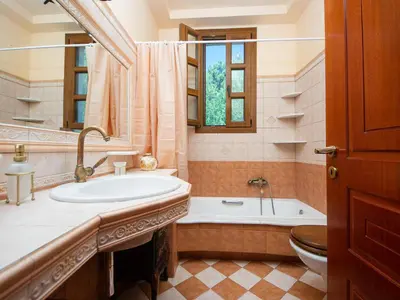 a bathroom with a tub and a sink and a toilet at Butterfly Garden Villa in Pastida