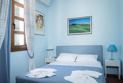 a blue bedroom with a bed with towels on it at Butterfly Garden Villa in Pastida